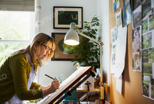 Preview: Woman standing at a drawing board, drawing with a fineliner.