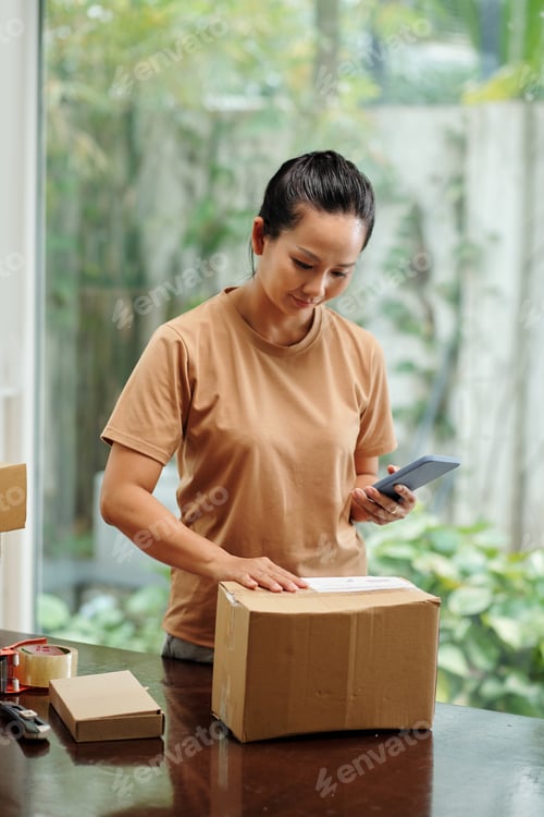 Preview: Woman Preparing Package for Shipping at Home