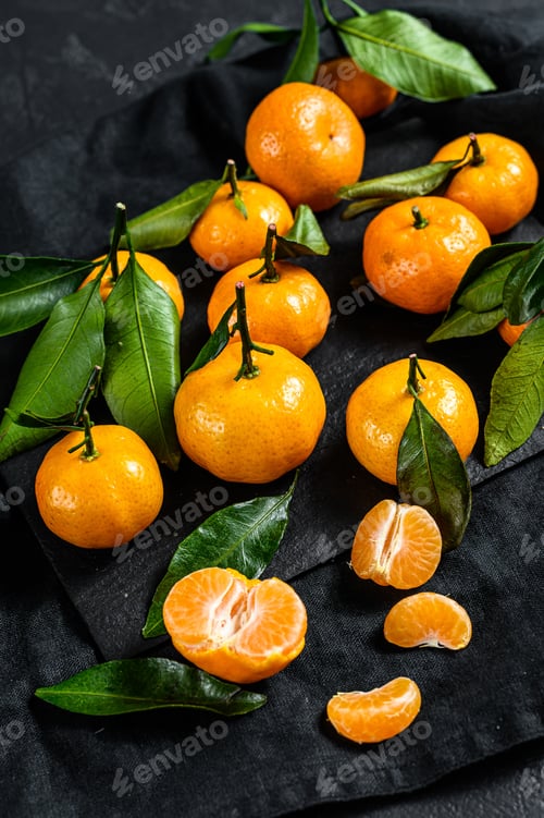 Preview: Tangerines, mandarines with leaves. Black background. Top view