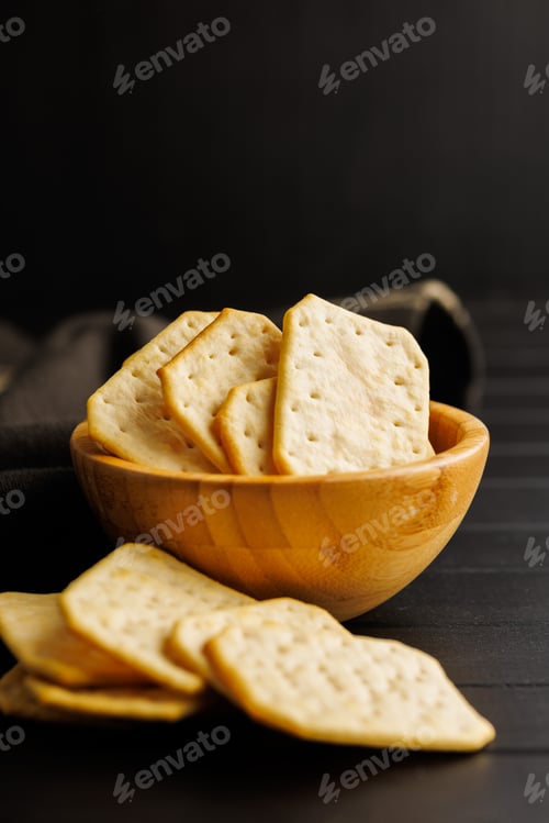 Preview: Salted Crackers in bowl Against a Dark Background