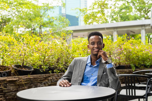 Preview: Portrait of handsome young black man outdoors in city