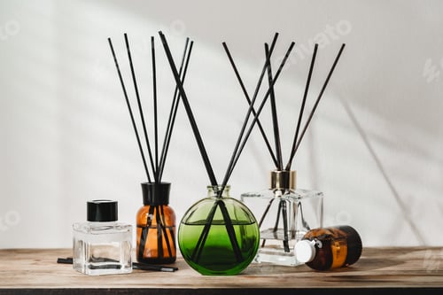 Preview: A Collection of Aromatic Reed Diffusers on a Wooden Table Against a Neutral Background
