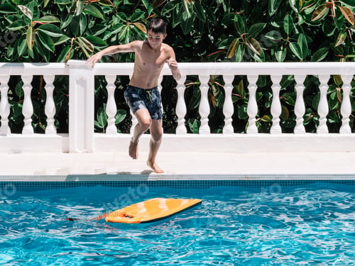 Preview: Pre-teens play in the pool by jumping on a small surfboard to keep their balance.