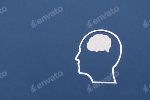 Preview: White Silhouette of head with puzzle brain symbolizing problem-solving on dark blue background