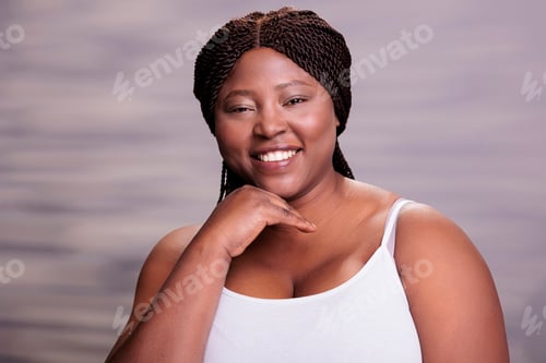 Preview: Attractive african american curvy woman holding hand on face