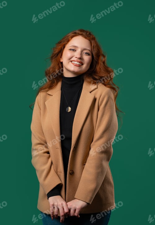 Preview: Friendly woman, red curly hair on green studio background.Smiling business lady