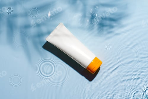 Preview: Tropical setting with a skincare tube resting on textured white surface illuminated by sunlight