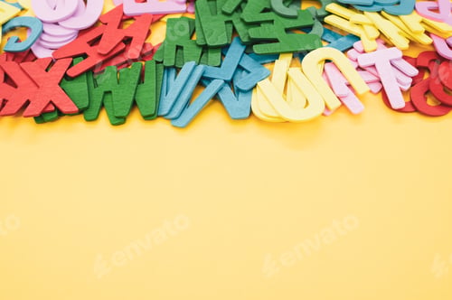 Preview: Top view closeup of the letters of the English alphabet isolated on a yellow background