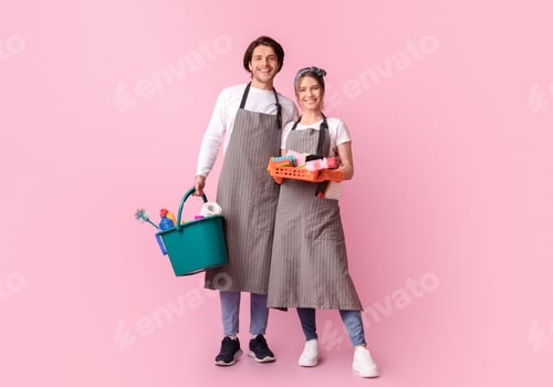 Preview: Professional Cleaners. Happy Couple In Aprons With Cleaning Tools In Hands