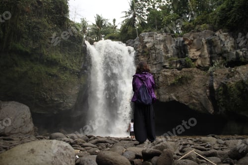 Preview: A young girl in a giant waterfall next to the village of Ubud in Bali