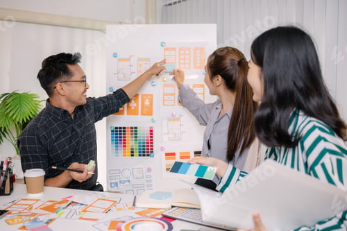 Preview: Designers having a UX/UI planning meeting to refine mobile app layouts and user flow.