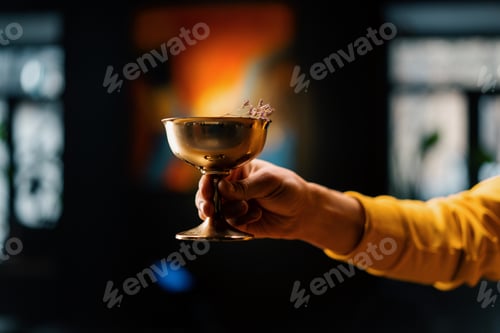 Preview: Close-up of a bar guest holding ready-made delicious stewed fruit alcoholic cocktail in his hand
