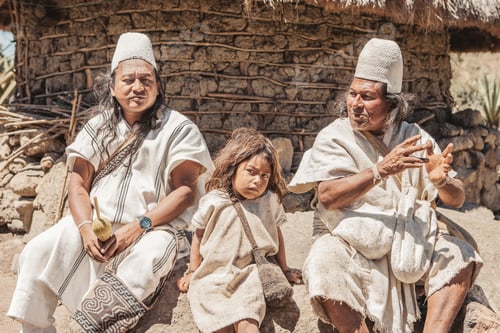Preview: The grandfather, father and son of an indigenous family pose in front in their traditional costume.