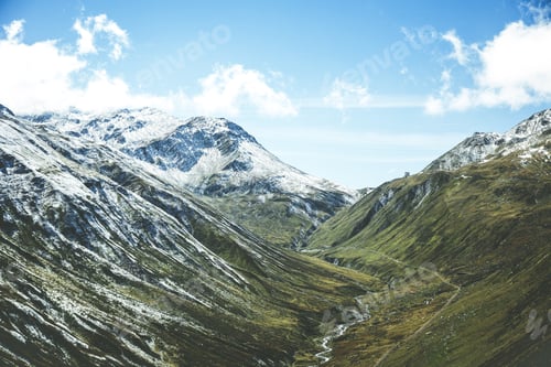 Preview: Beautiful shot of snowy mountains under a blue cloudy sky at daytime