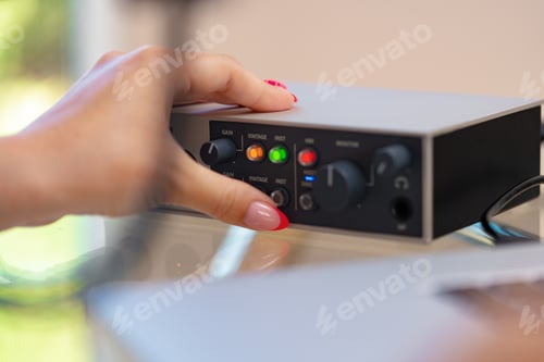 Preview: Unrecognizable young woman hands adjusting audio mixer setting sound in home studio close up