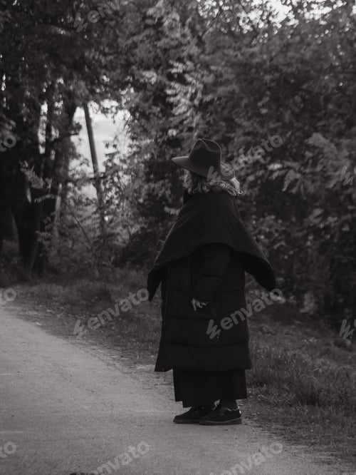 Preview: senior woman , autumn season, wear black dress and purple hat, walking outdoors