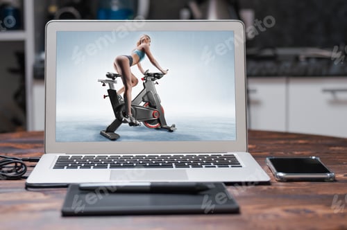 Preview: Beautiful Slender And Long-Legged Girl Sits On An Exercise Bike. Side View. The Concept Of Sports