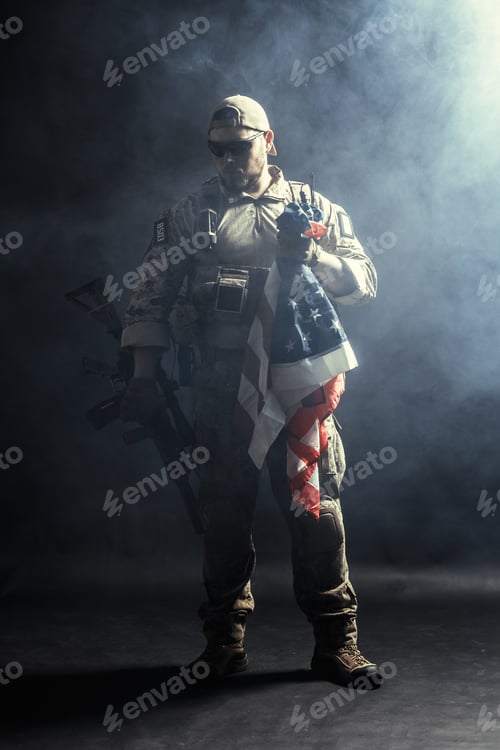 Preview: Soldier stands with American flag in a smoky setting with tactical gear and weapons