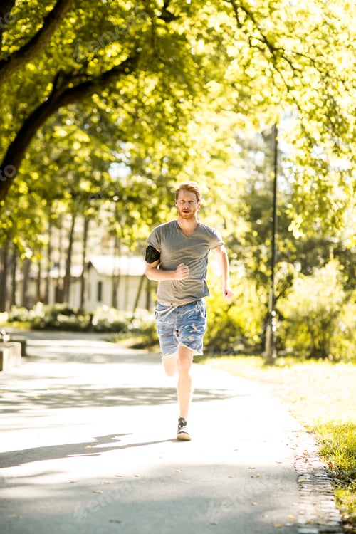 Preview: Young man running in the autumn park