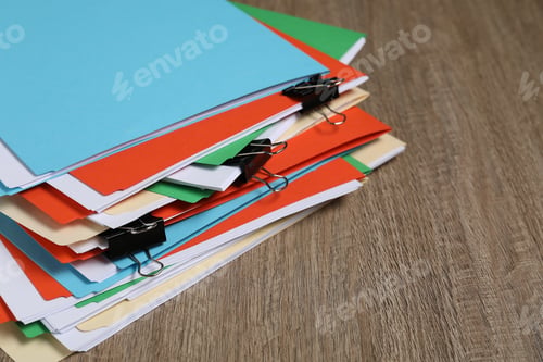 Preview: Many documents in folders with binder clips on wooden table, closeup