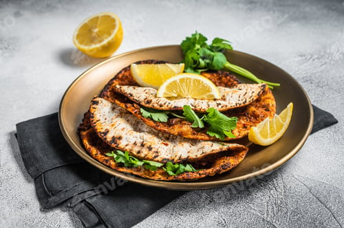 Vista previa: Turkish lahmacun pizza with mince meat and tomatoes on a plate with parsley and lemon.