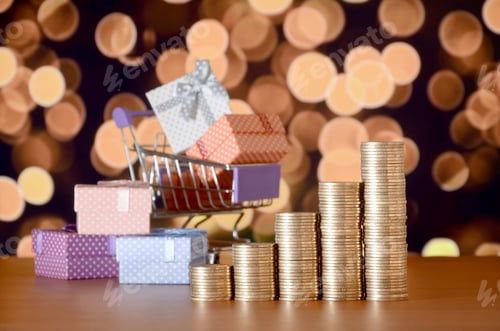 Preview: Small red gift box and golden coin stacks on the colored bokeh background