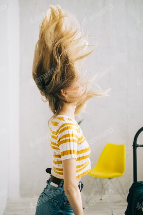 Preview: Young attractive caucasian woman shaking her blonde hair.
