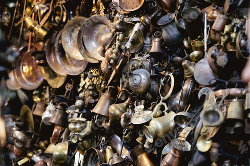Preview: antique metallic pots and plates hanging on a wall