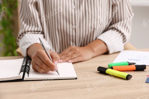 Preview: Woman using business planner at wooden table in office, closeup