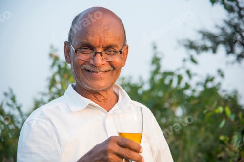Preview: Senior cheerful man holding a glass of alcohol in his hand, ready to drink it.