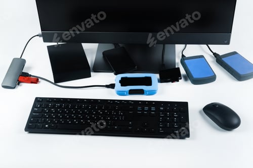 Preview: Multiple external hard drives connected to a monoblock on a white background.Computer with hard