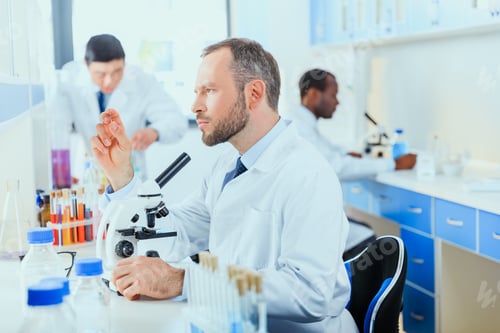Researchers Working with Microscope in Modern Laboratory