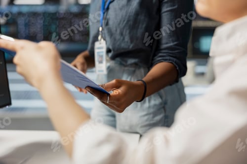 Preview: Server room employees reviewing documentation on clipboard, close up