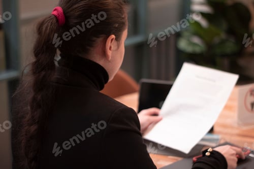 Preview: Beautiful businesswoman in a black classic jacket girl holding paper in the office