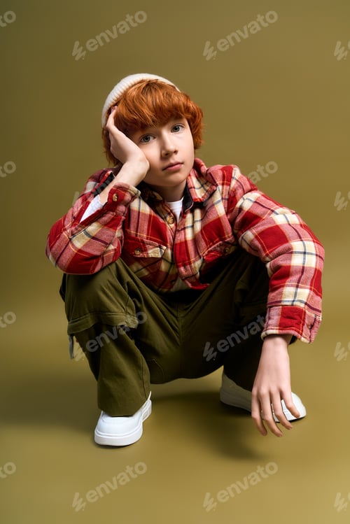 Preview: Charming little boy in stylish outfit captures a moment of creativity and joy indoors