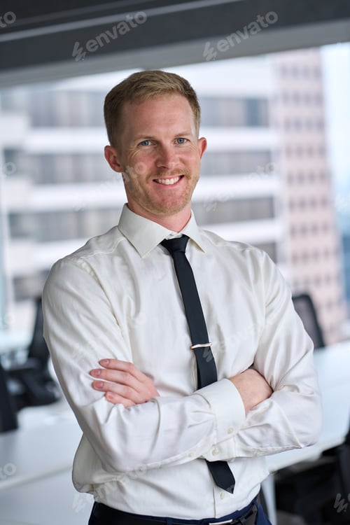 Preview: Happy young business man wearing tie looking at camera in office, portrait.