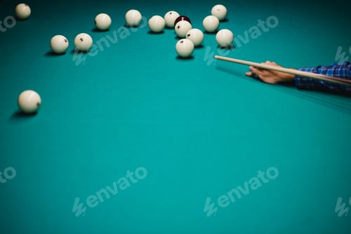 Preview: game of billiards the hand of a man with a billiard cue aims at a billiard ball