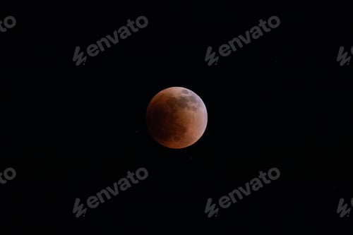 Preview: Blood moon total lunar eclipse super moon rising against dark sky