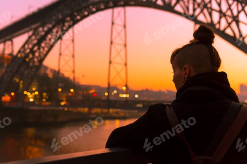 Preview: Woman looking at river and city in evening