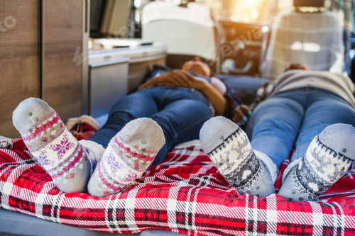 Preview: Mature women sleeping inside mini van camper wearing Christmas warm socks