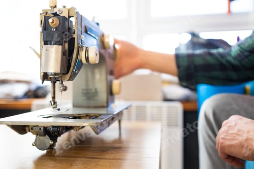 Preview: Repairman master is testing old disassembles sewing machine in workshop repairing it sitting at tabl