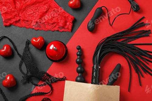 Preview: Paper shopping bag with different sex toys on color background, flat lay