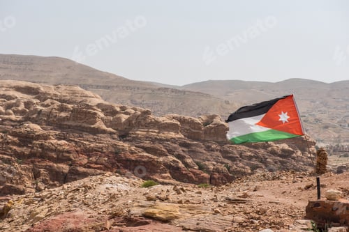 Preview: The flag of Jordan blowing in the wind in Petra, Jordan