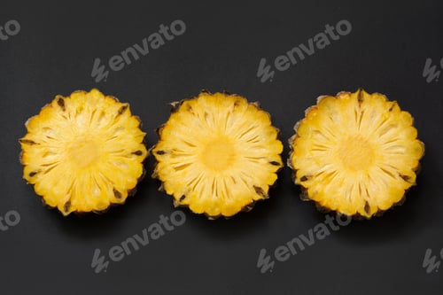 Preview: Isolated tropical sliced pineapple on black. Close up. Top view.