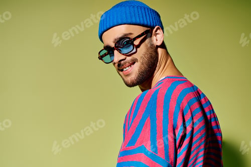Preview: Young man showcases vibrant fashion sense with stylish outfit and sunglasses in studio