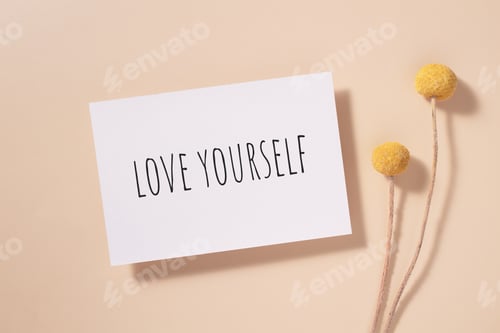 Preview: Love yourself word written on card. Invitation card with craspedia flowers on beige background.