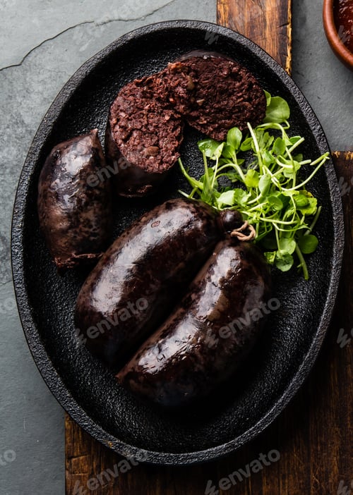 Preview: Bloody sausages - chilean preta on iron plate, top view, grey slate background