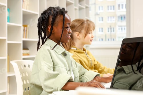 Preview: African American boy playing computer with friend, learning at technology class