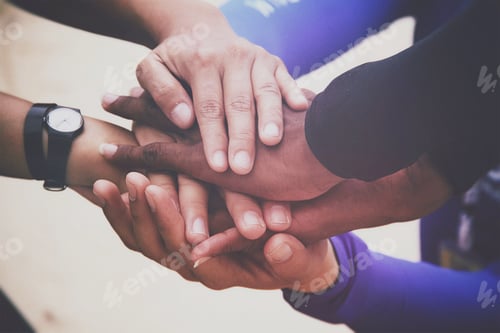 Preview: Diverse group of people holding hands in supportive gesture