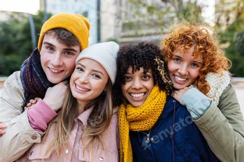 Preview: Young group of diverse people smiling at camera standing outdoors in winter